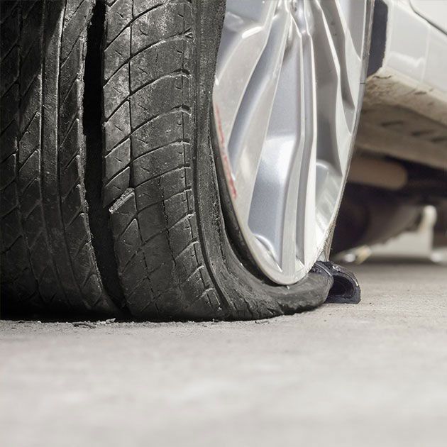 A car with a flat tire on the ground.