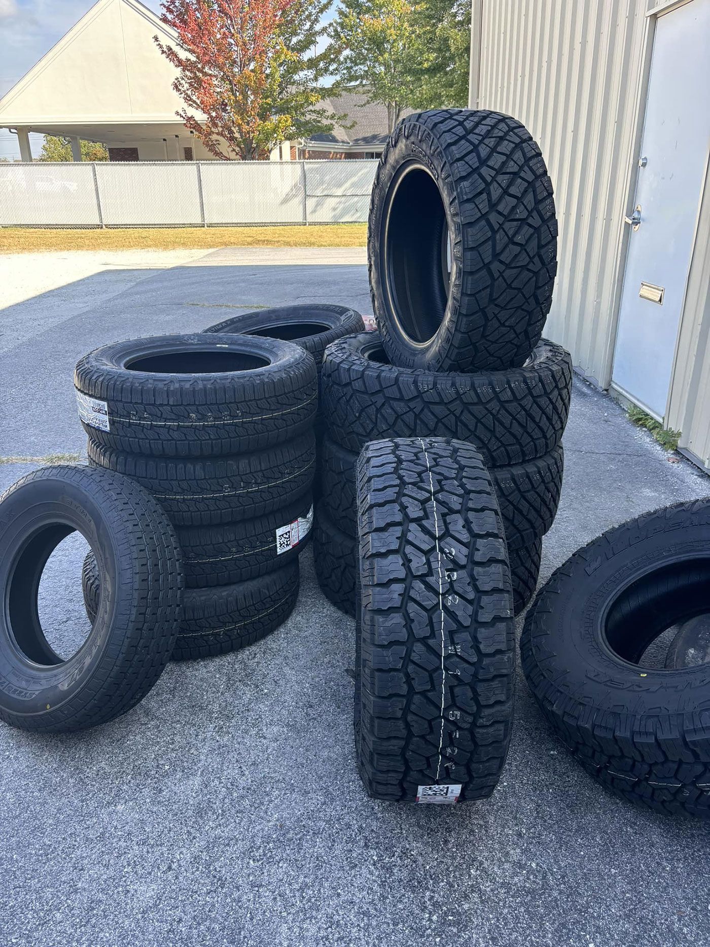 A bunch of tires are stacked on top of each other on the ground.