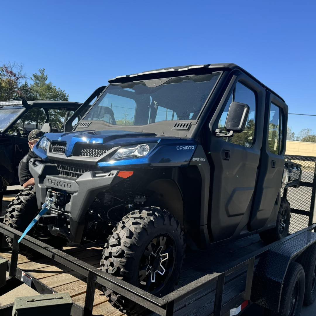 A blue and black atv is parked on a trailer