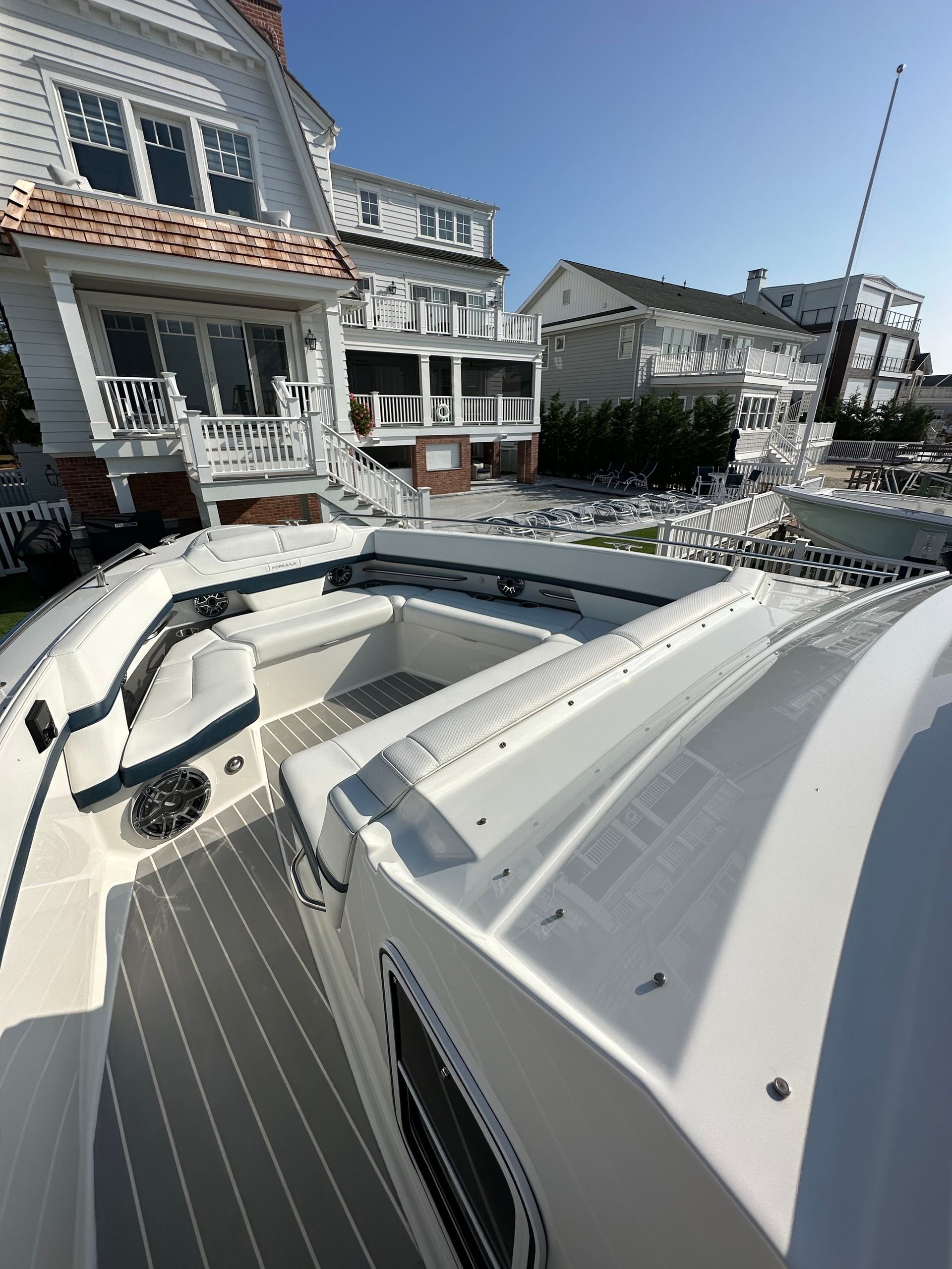a white boat is docked in front of a house