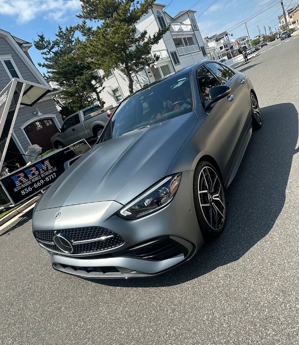 a car is parked in front of a sign that says RBM