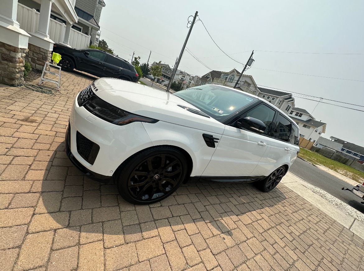 a white Range Rover is parked on a brick driveway