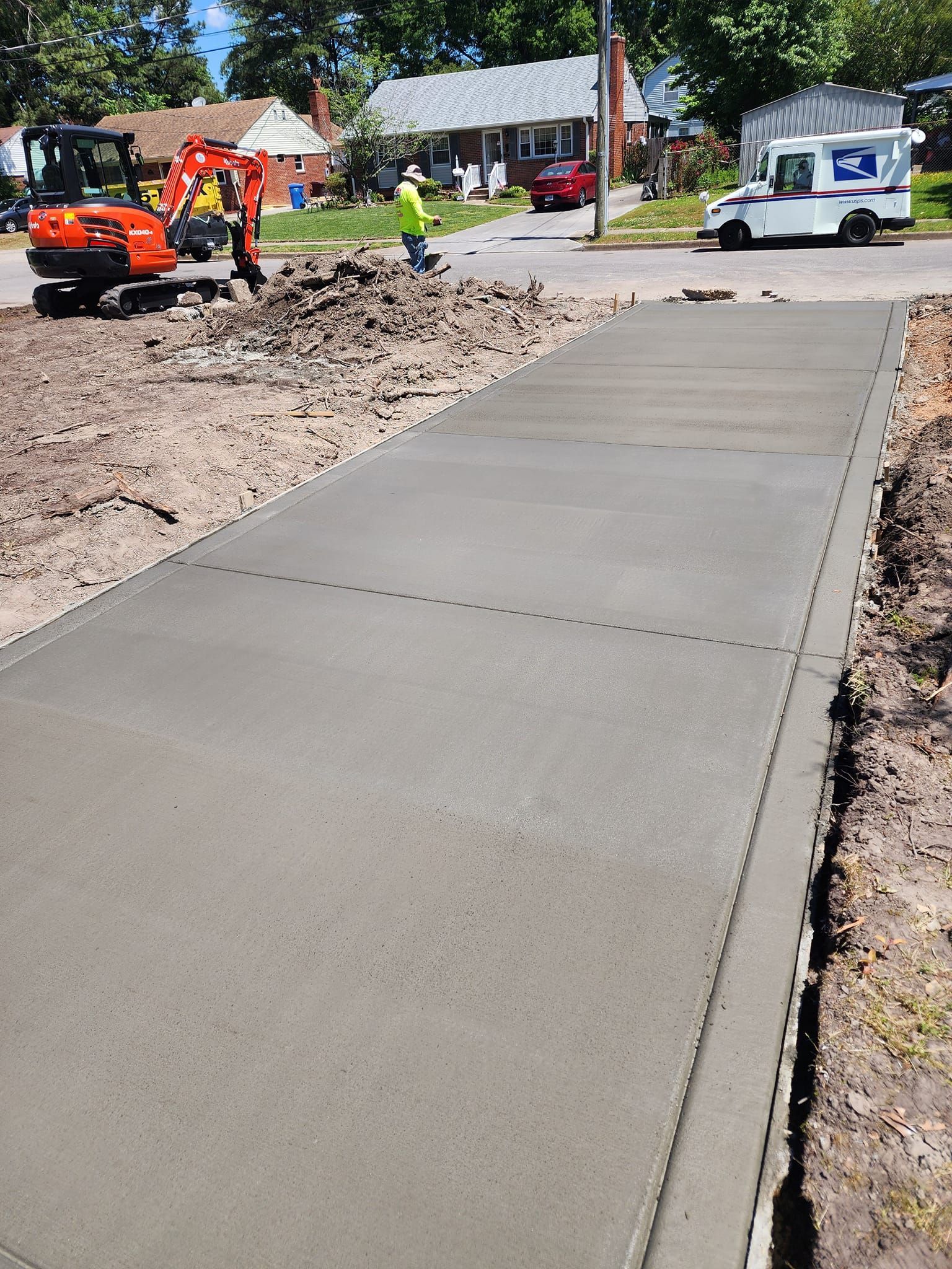 A concrete walkway is being built on the side of a road.