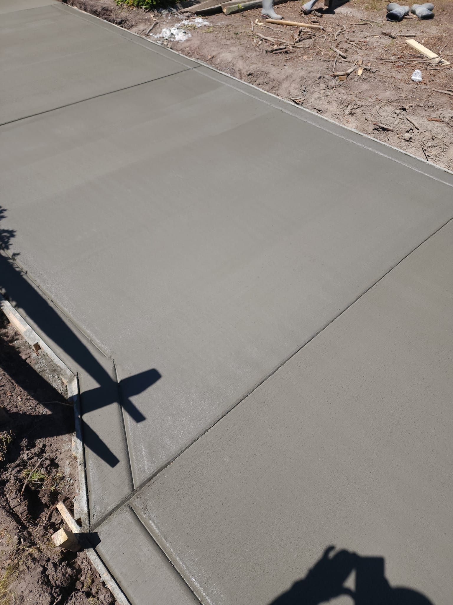 A person is taking a picture of a concrete driveway.