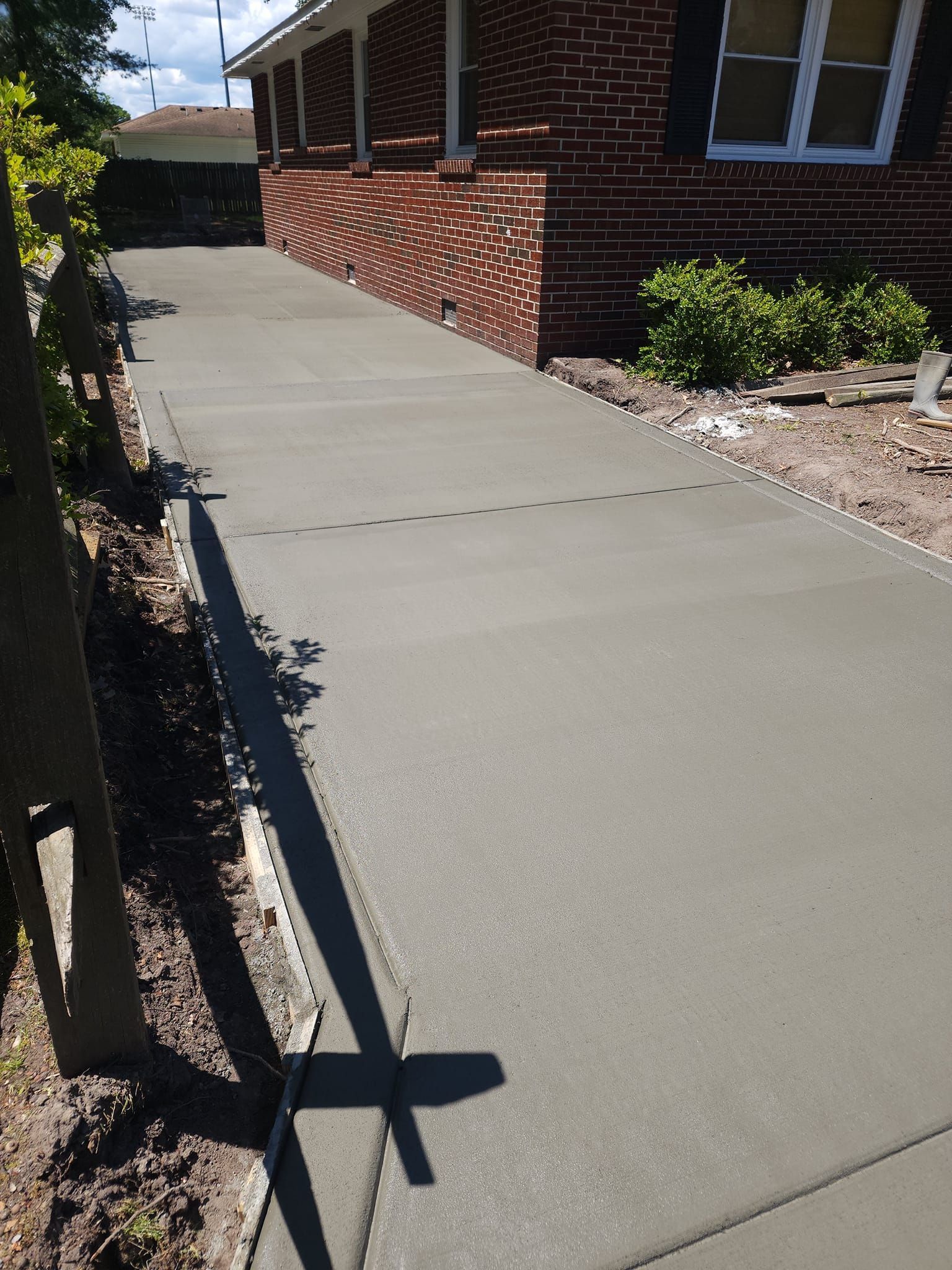 A brick house with a concrete driveway in front of it.
