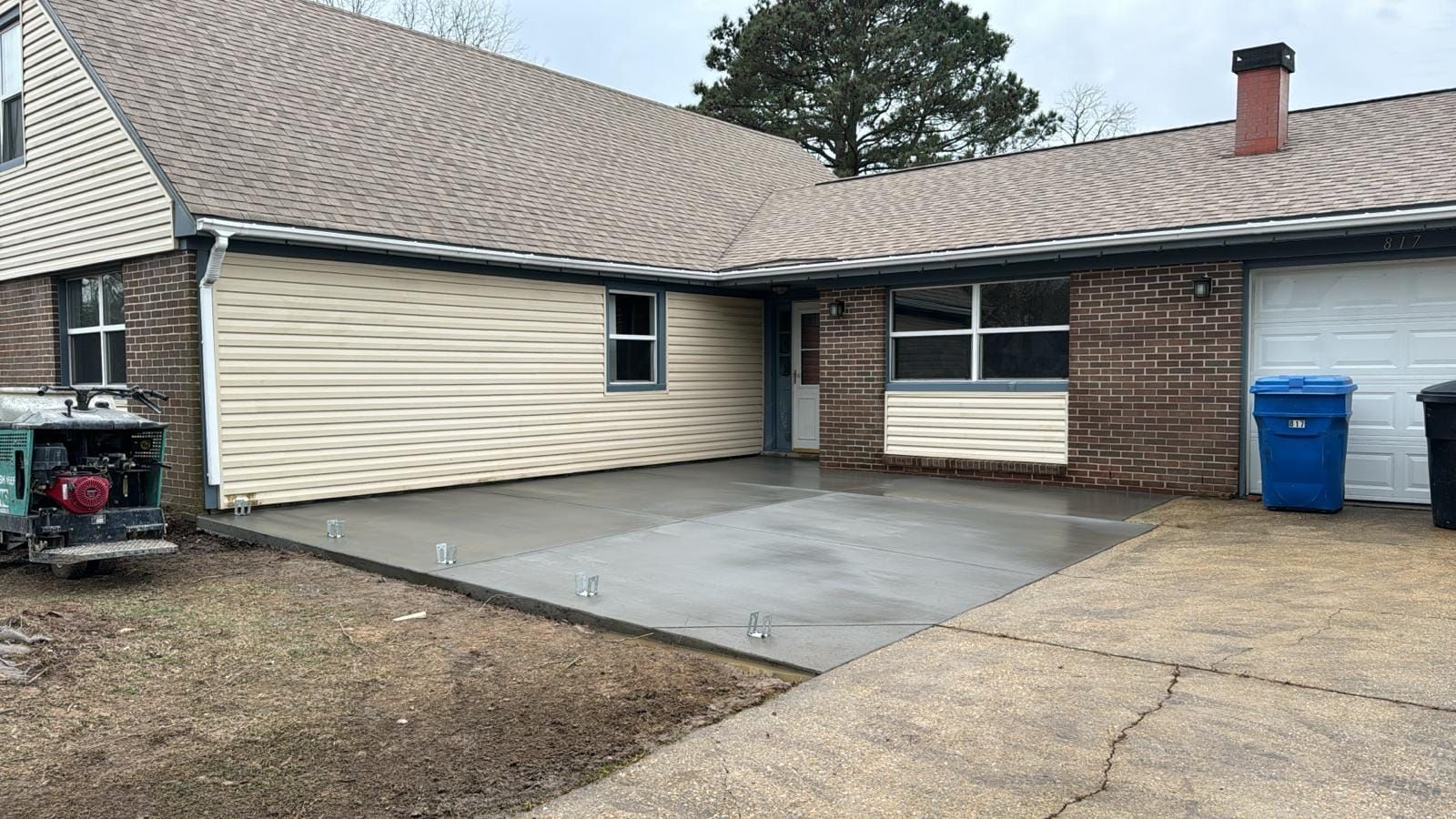 A house with a concrete driveway in front of it.