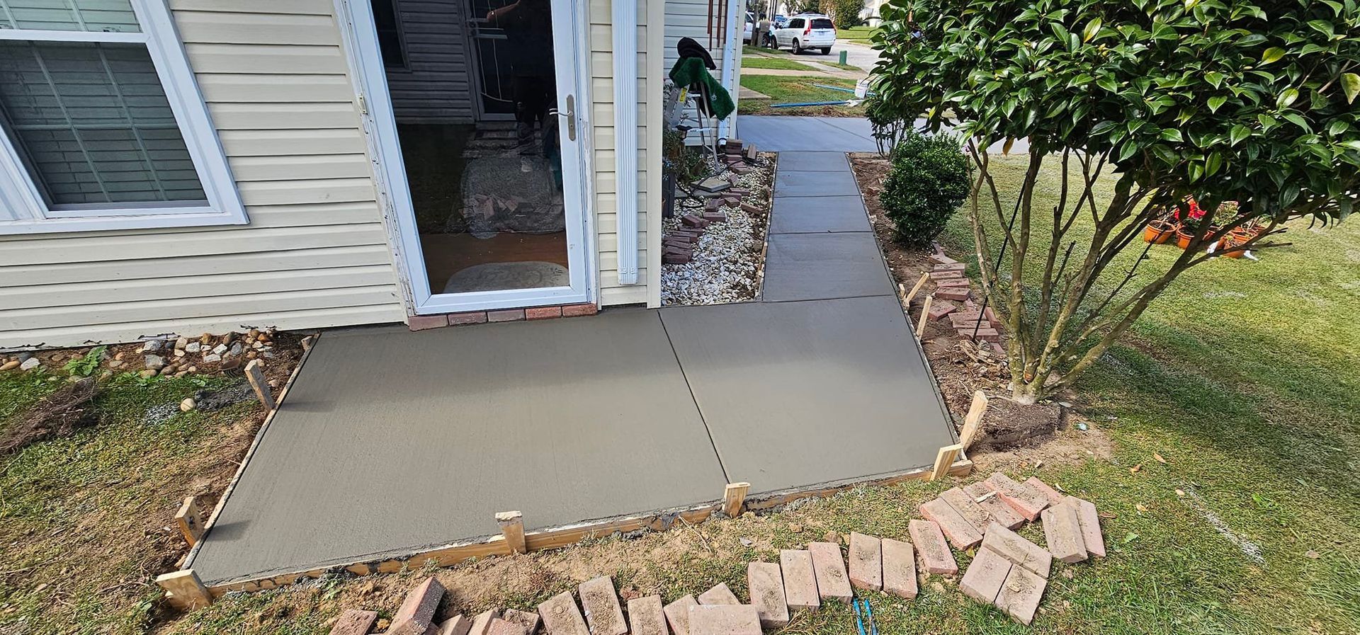A concrete walkway is being built in front of a house.