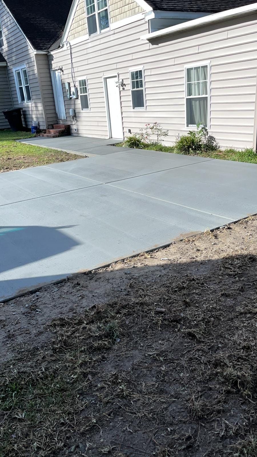 There is a concrete driveway in front of a house.