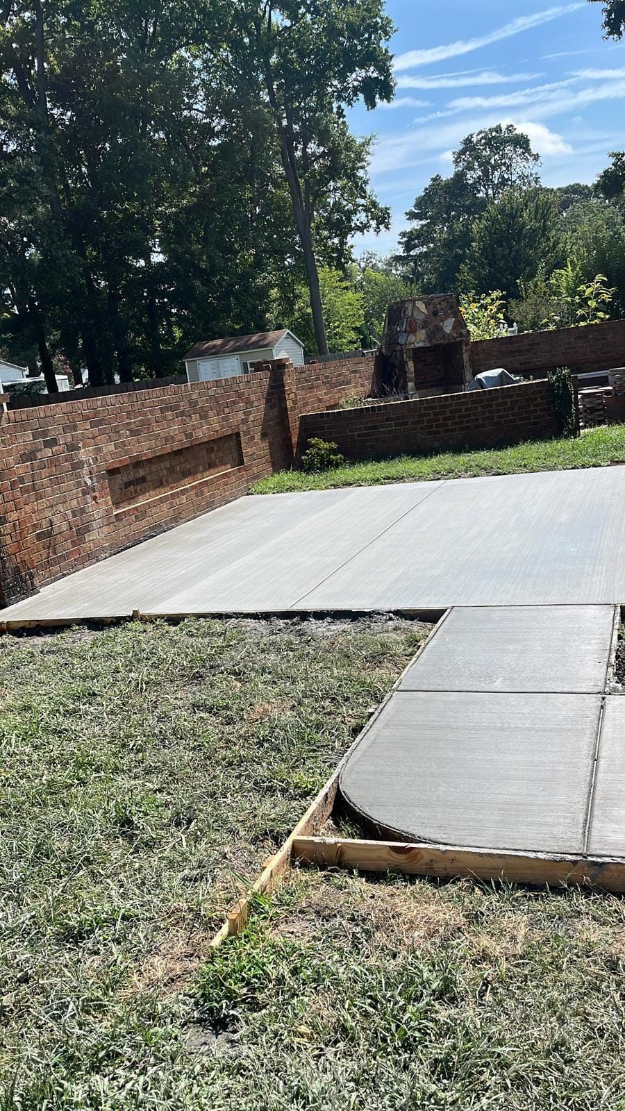 A concrete driveway is being built in a backyard.