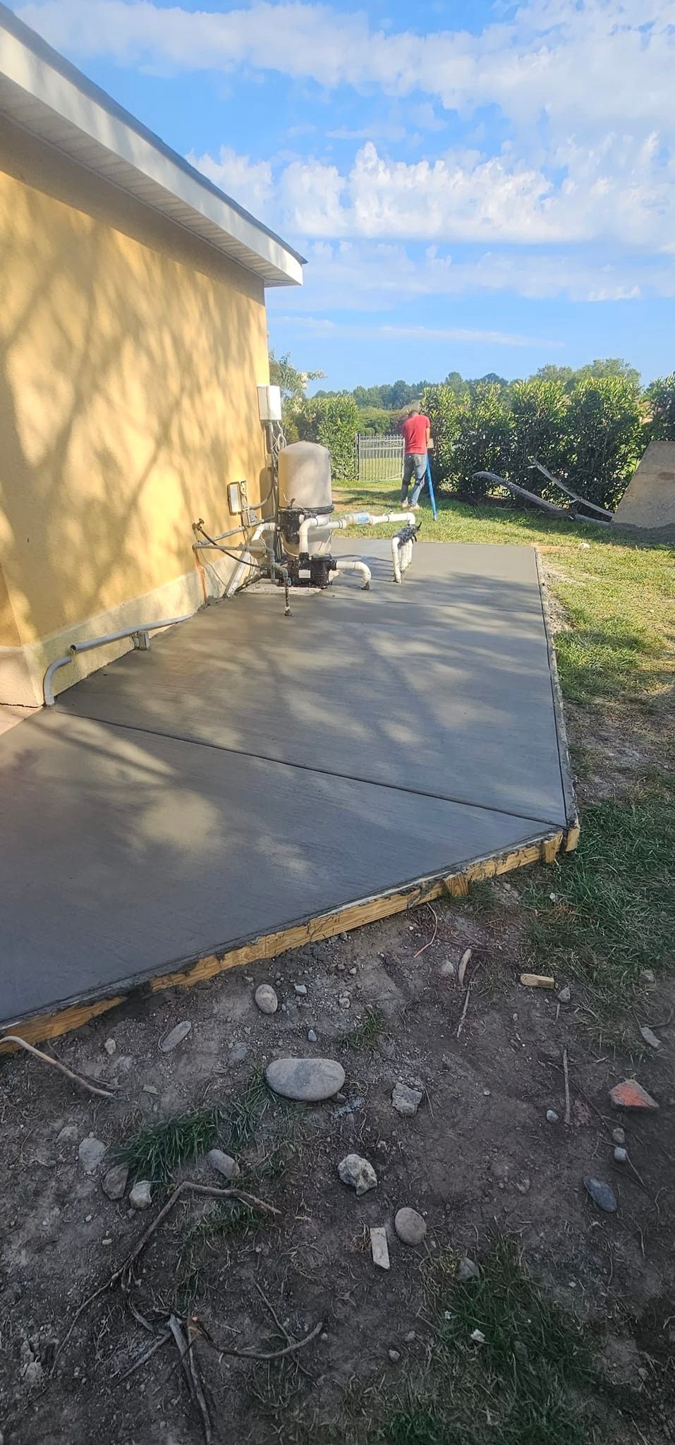 A concrete walkway is being built in front of a house.