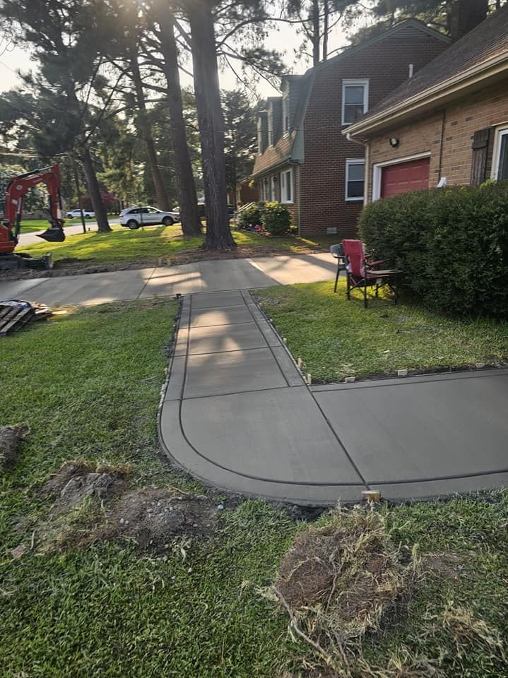 A concrete walkway is being built in front of a house.