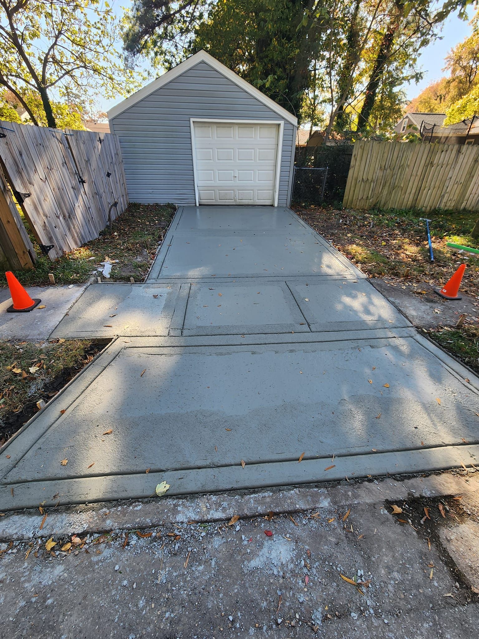 A concrete driveway leading to a garage with a white garage door.