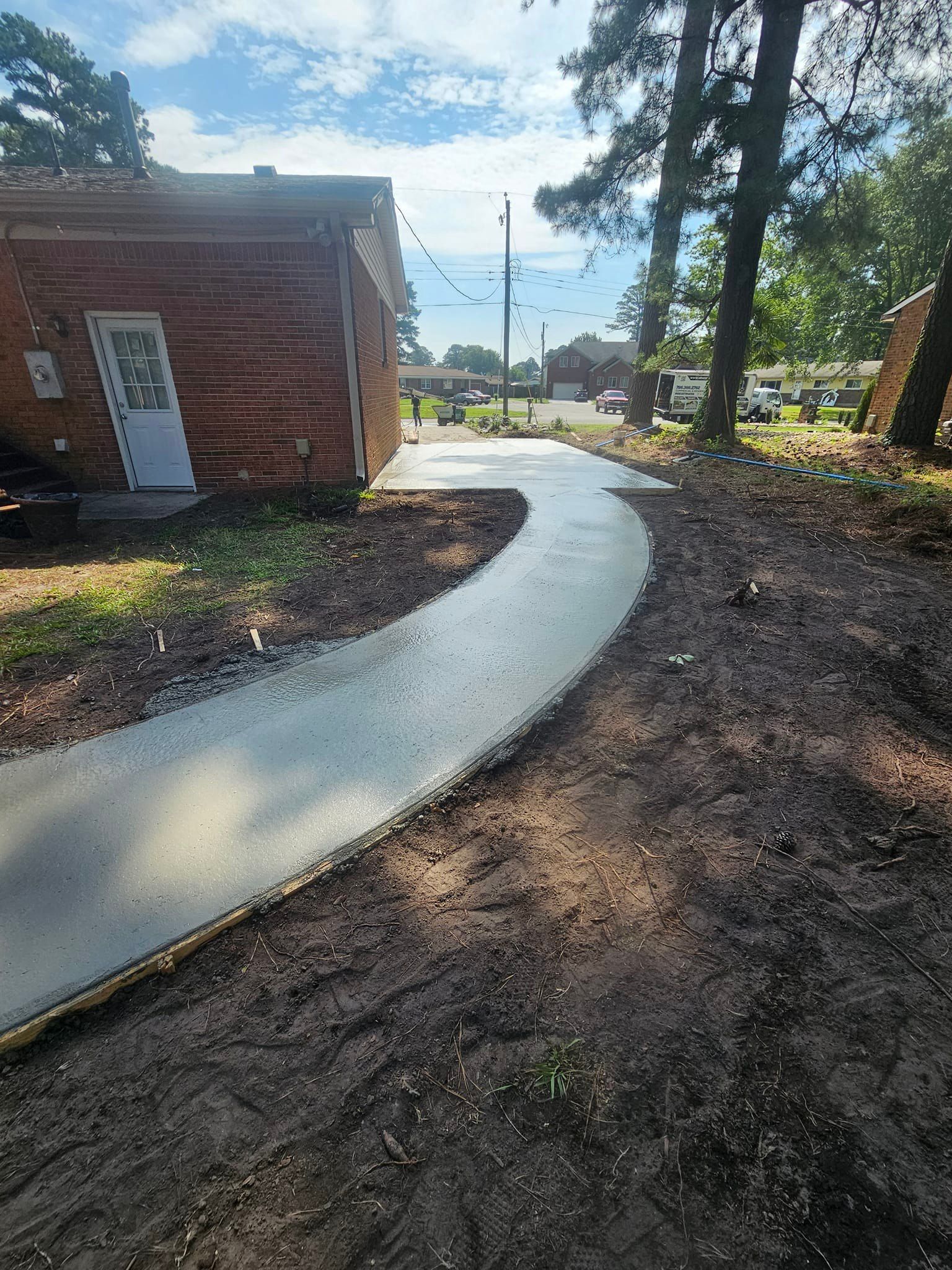A concrete walkway is being built in front of a brick building.