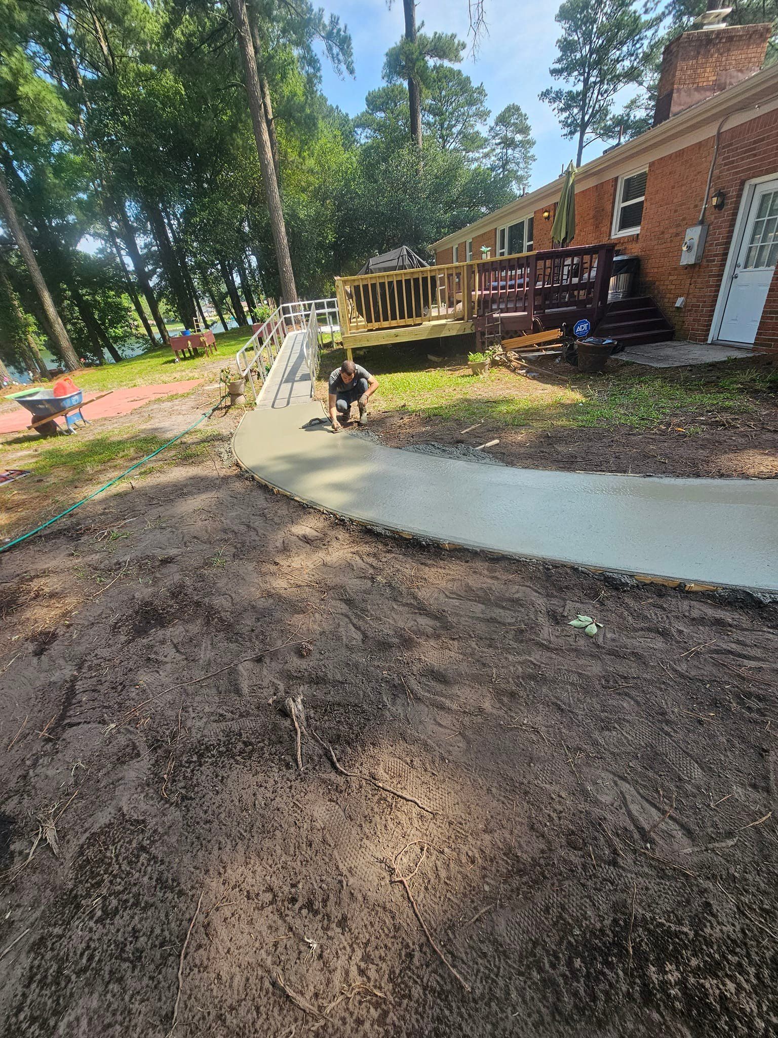 A person is standing on a sidewalk in front of a house.