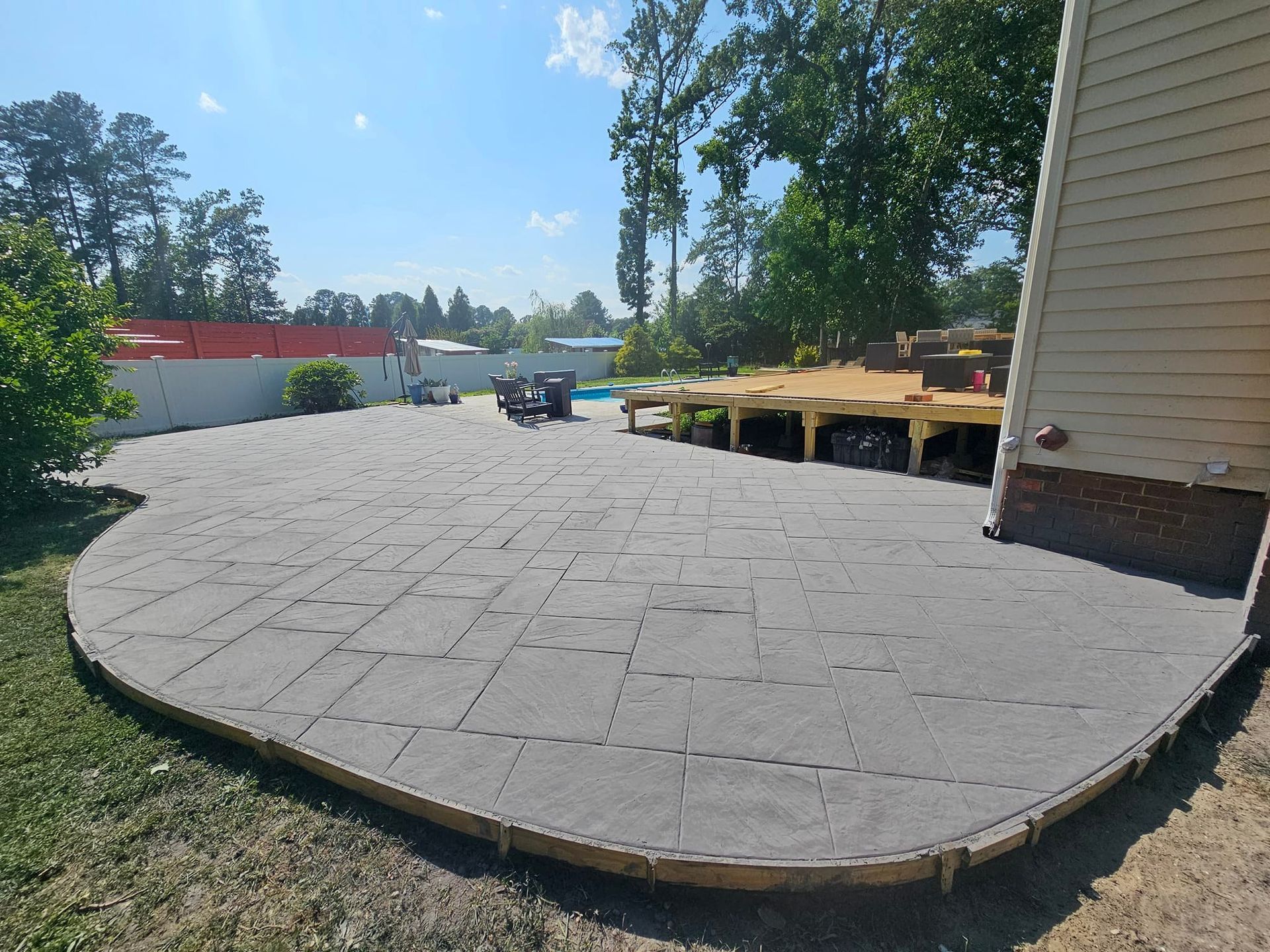 A concrete patio is being built in front of a house.