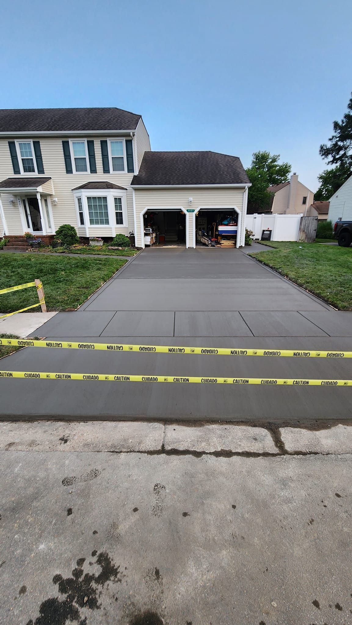 A concrete driveway is being built in front of a house.