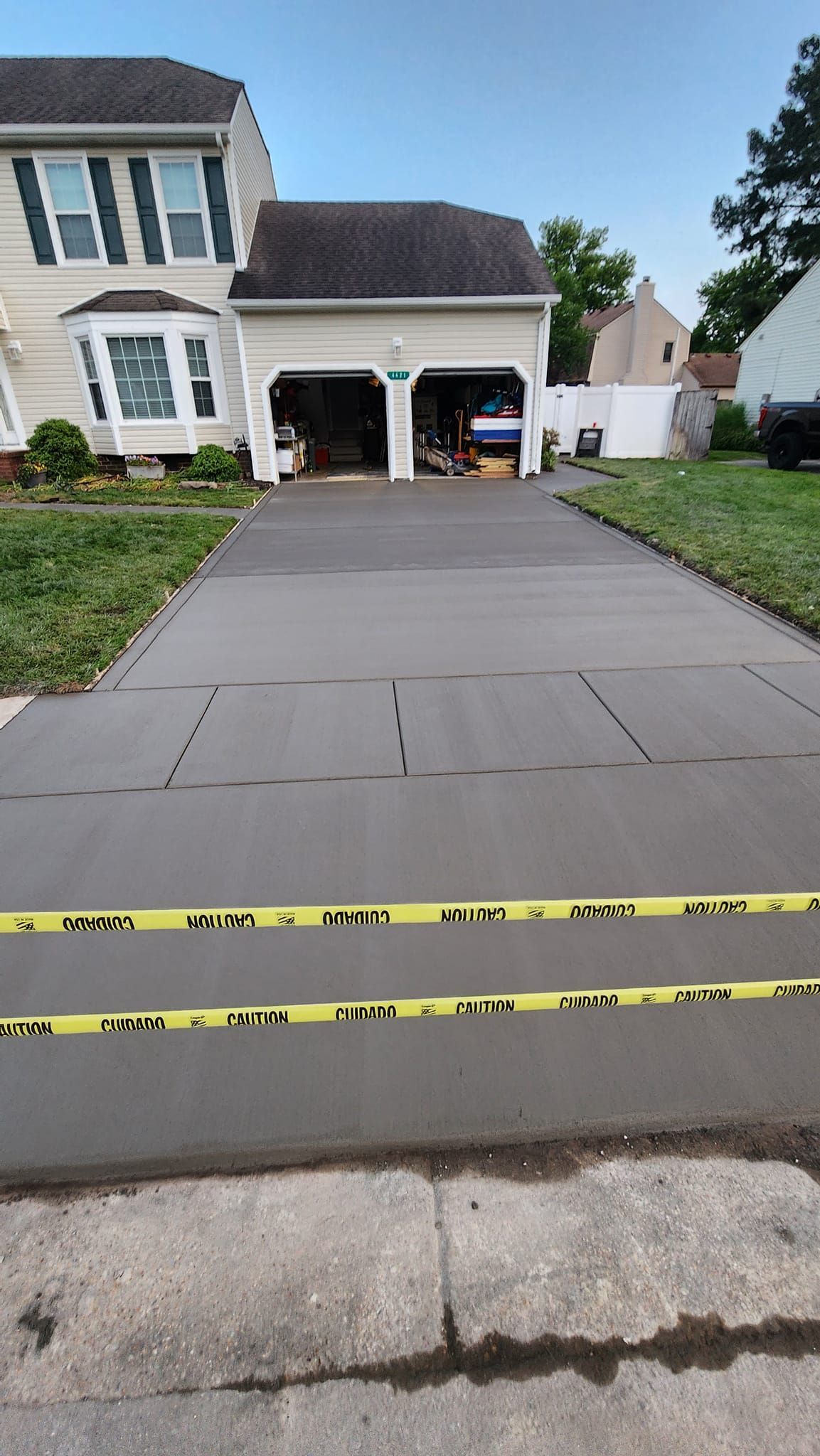 A concrete driveway leading to a house with a garage.