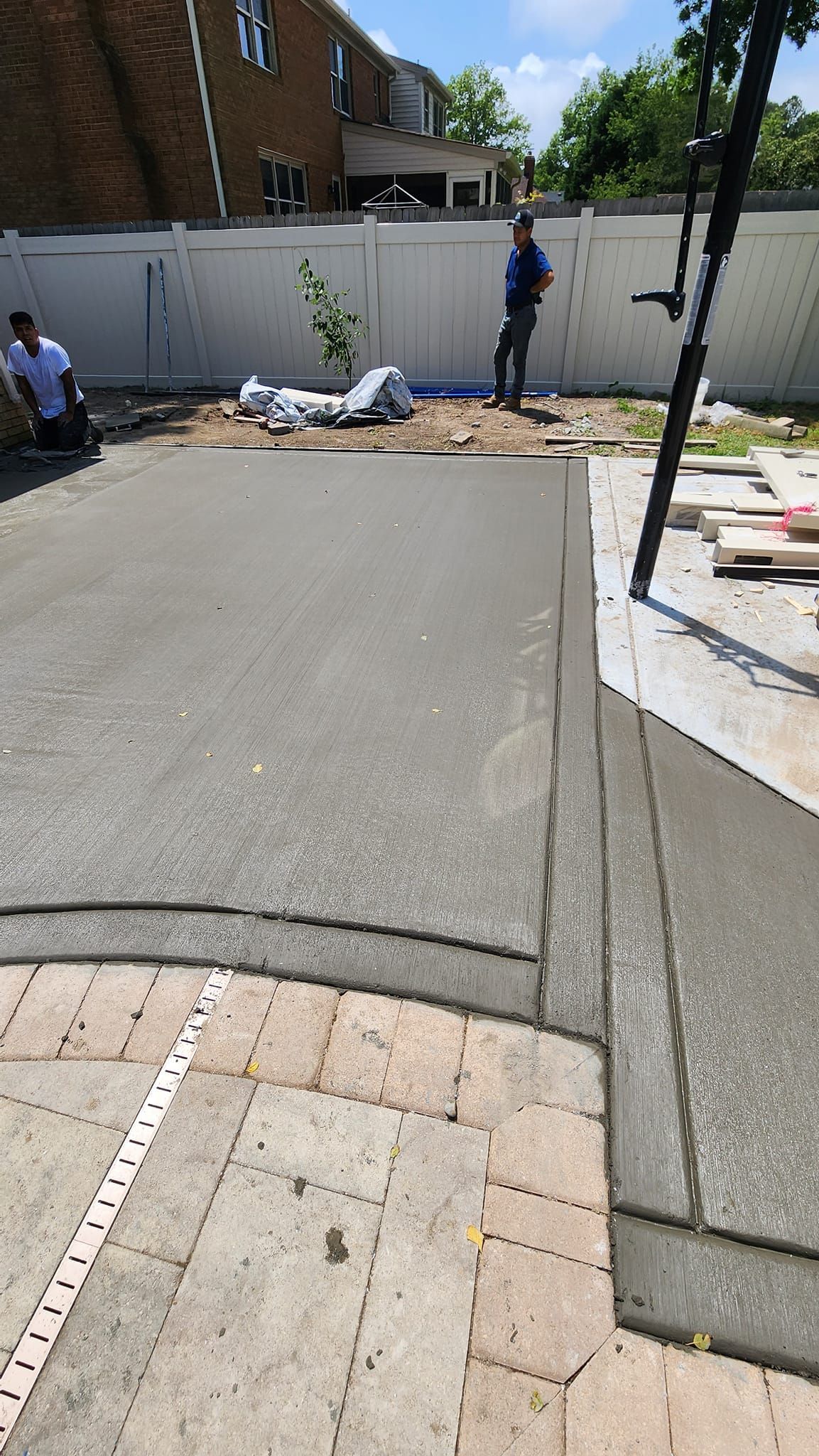 A man is standing in the middle of a concrete driveway.