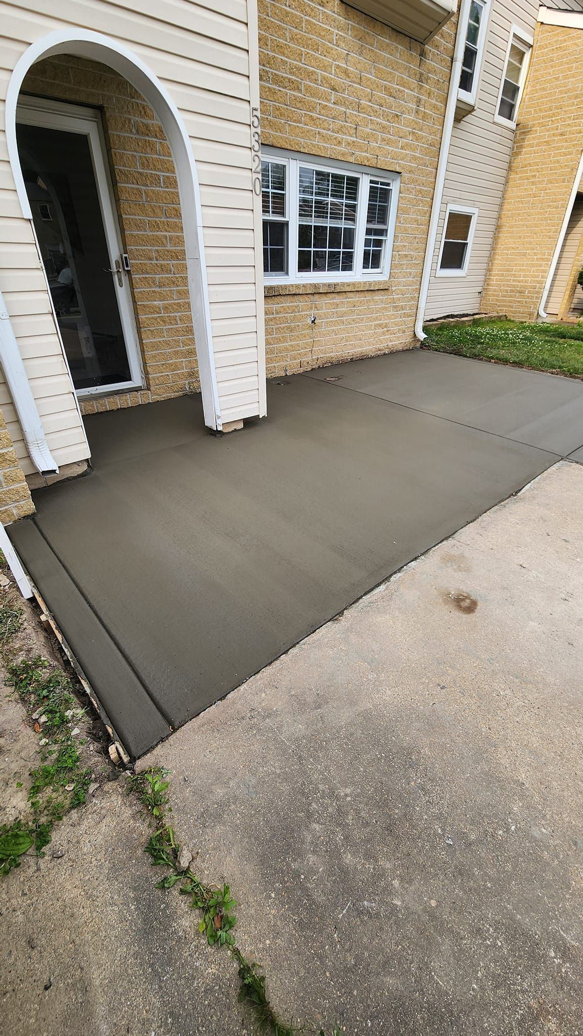 A concrete walkway is being built in front of a house.