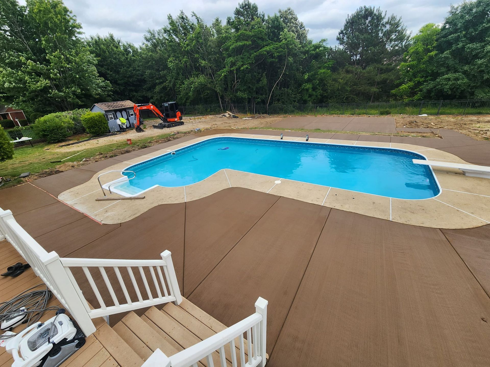 A large swimming pool is being built in a backyard.