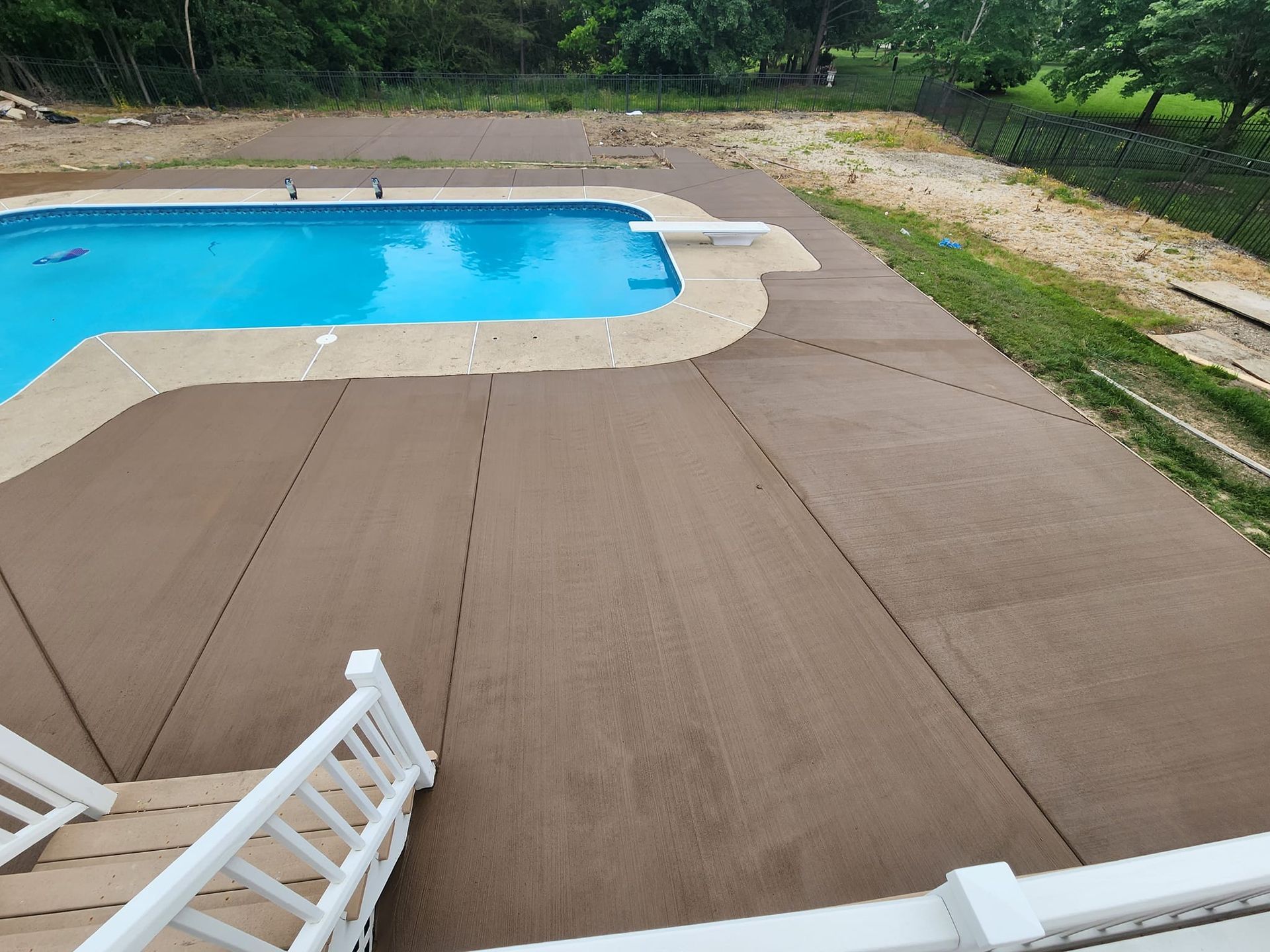 A large swimming pool is surrounded by a concrete deck.
