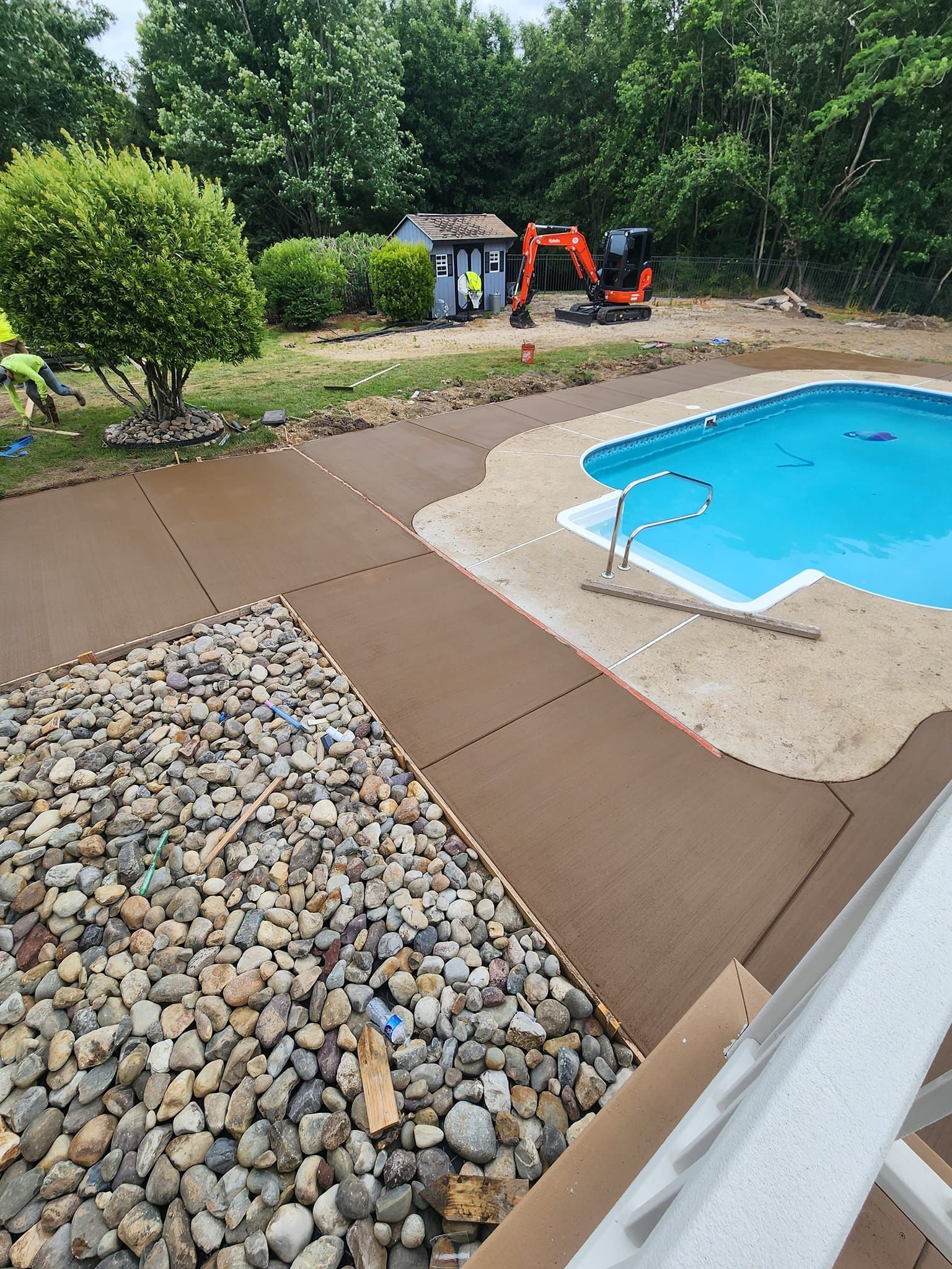 A swimming pool is being built in the backyard of a house.