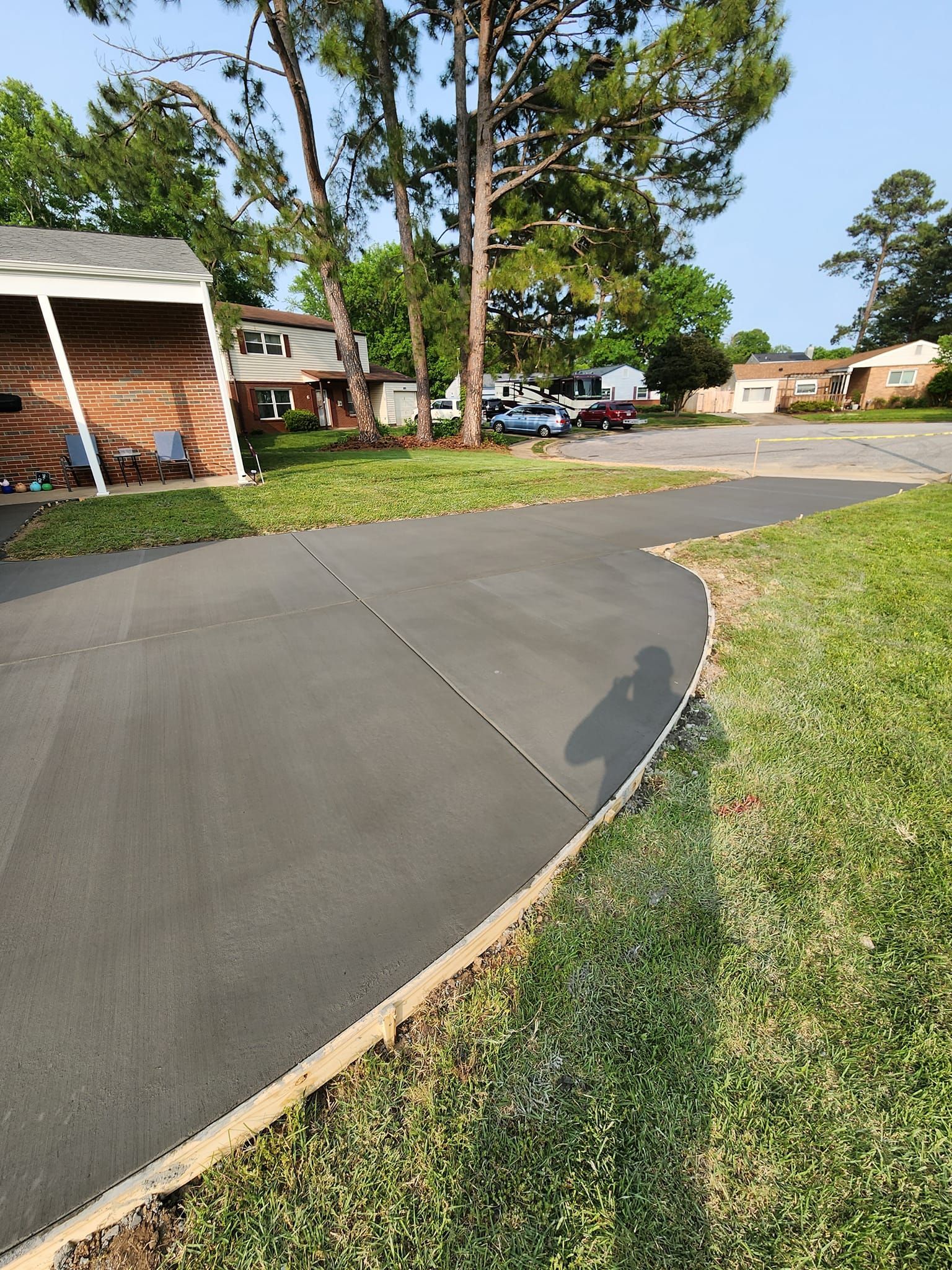 A concrete driveway leading to a house in a residential area.