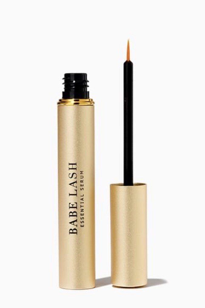 A tube of babe lash essential serum with a brush