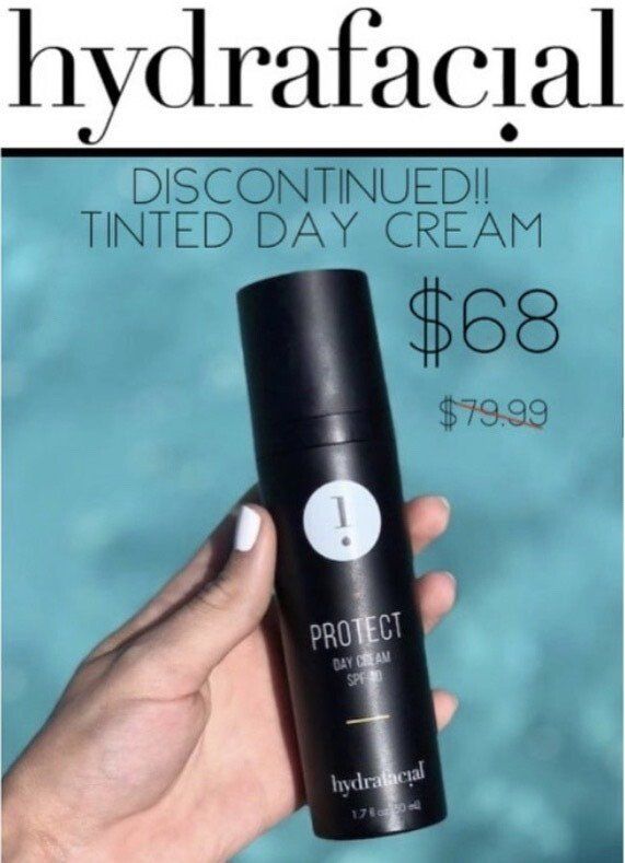 A person is holding a bottle of hydrafacial tinted day cream