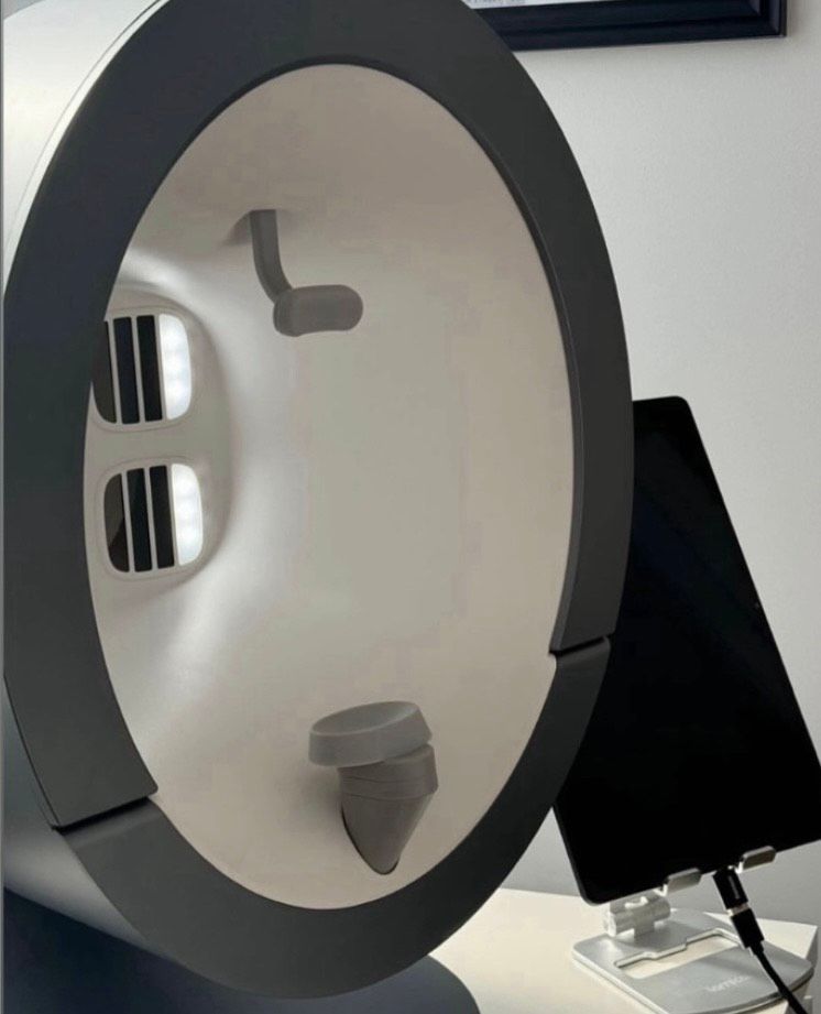 A circular device is sitting on a table next to a tablet