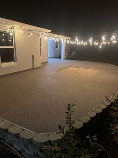 String lights over a large empty patio beside a house at night