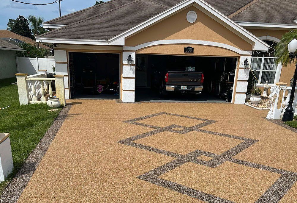 Two-car garage with a tan driveway decorated with a dark geometric pattern
