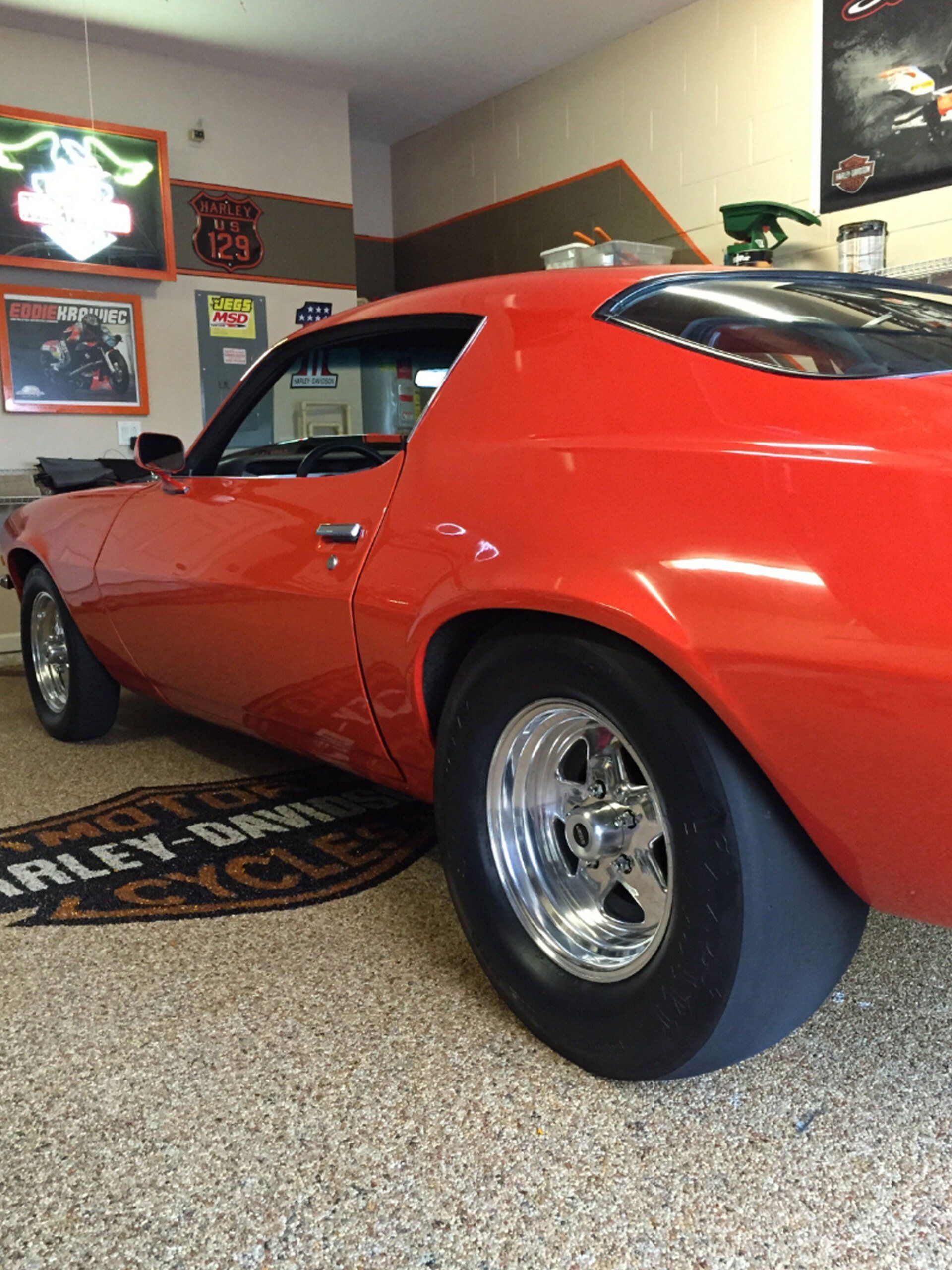 Red classic muscle car on display in a garage with polished concrete floor