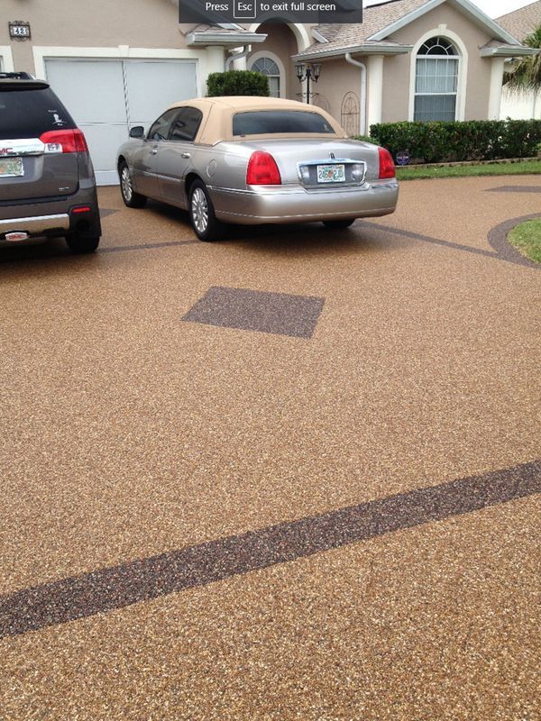 Silver sedan parked in a suburban driveway beside another car, in front of a house.