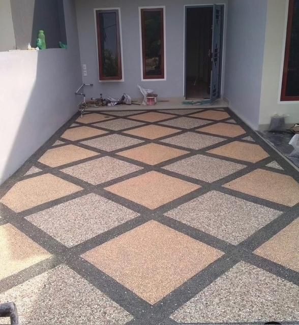 Tiled courtyard with a diamond-pattern floor leading to a house doorway and windows.