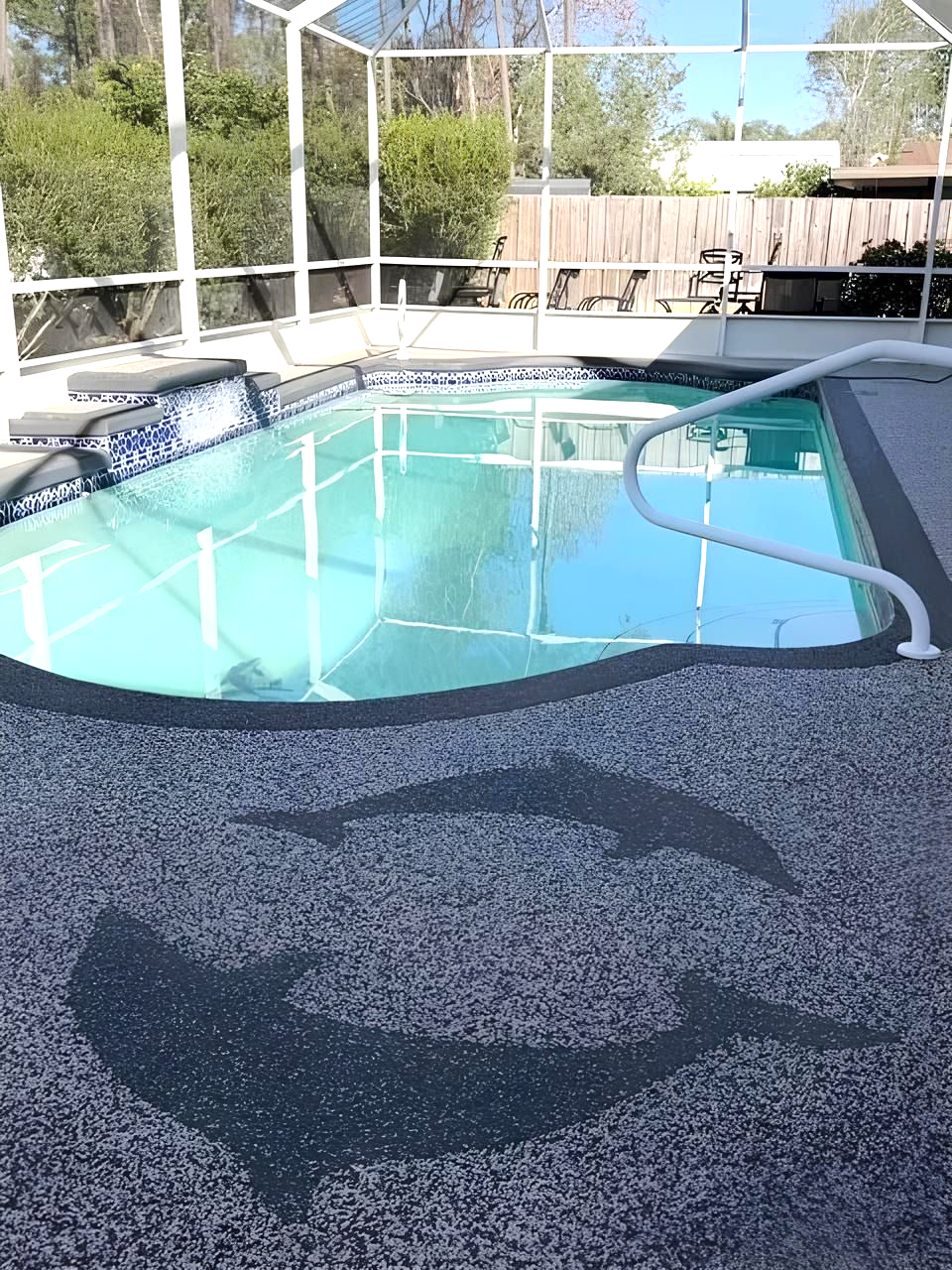 Backyard swimming pool with a safety cover partially pulled back and a white handrail visible