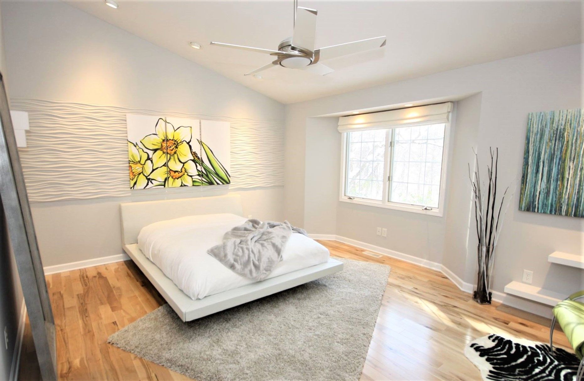 A bedroom with a bed and a ceiling fan