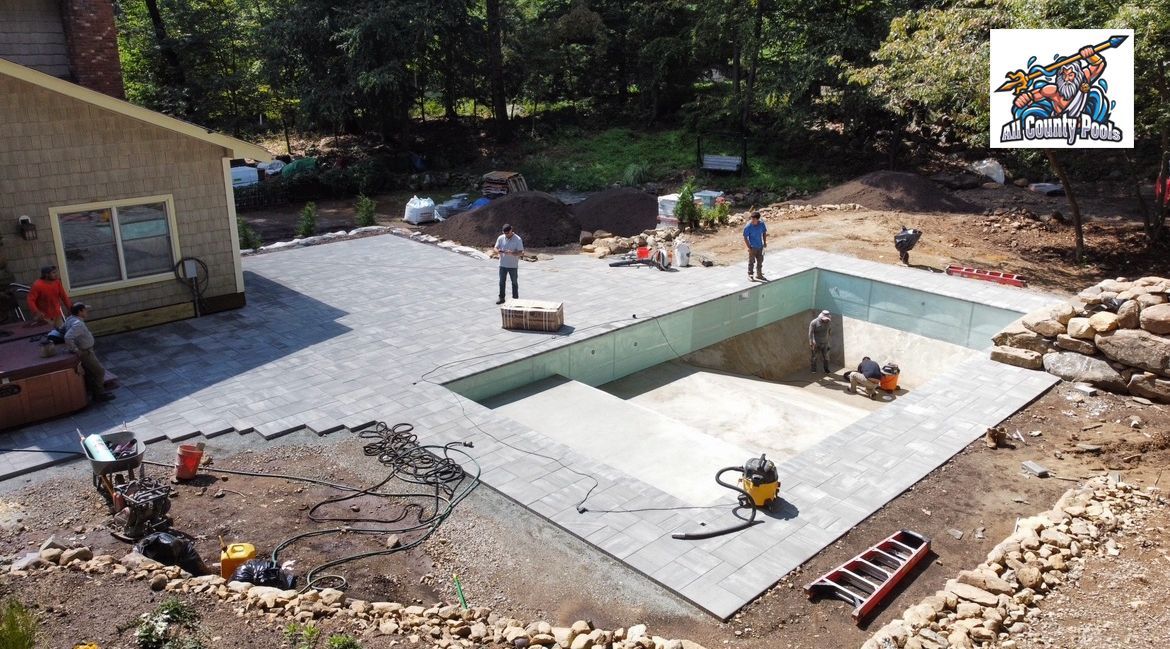 A large swimming pool is being built in the backyard of a house.