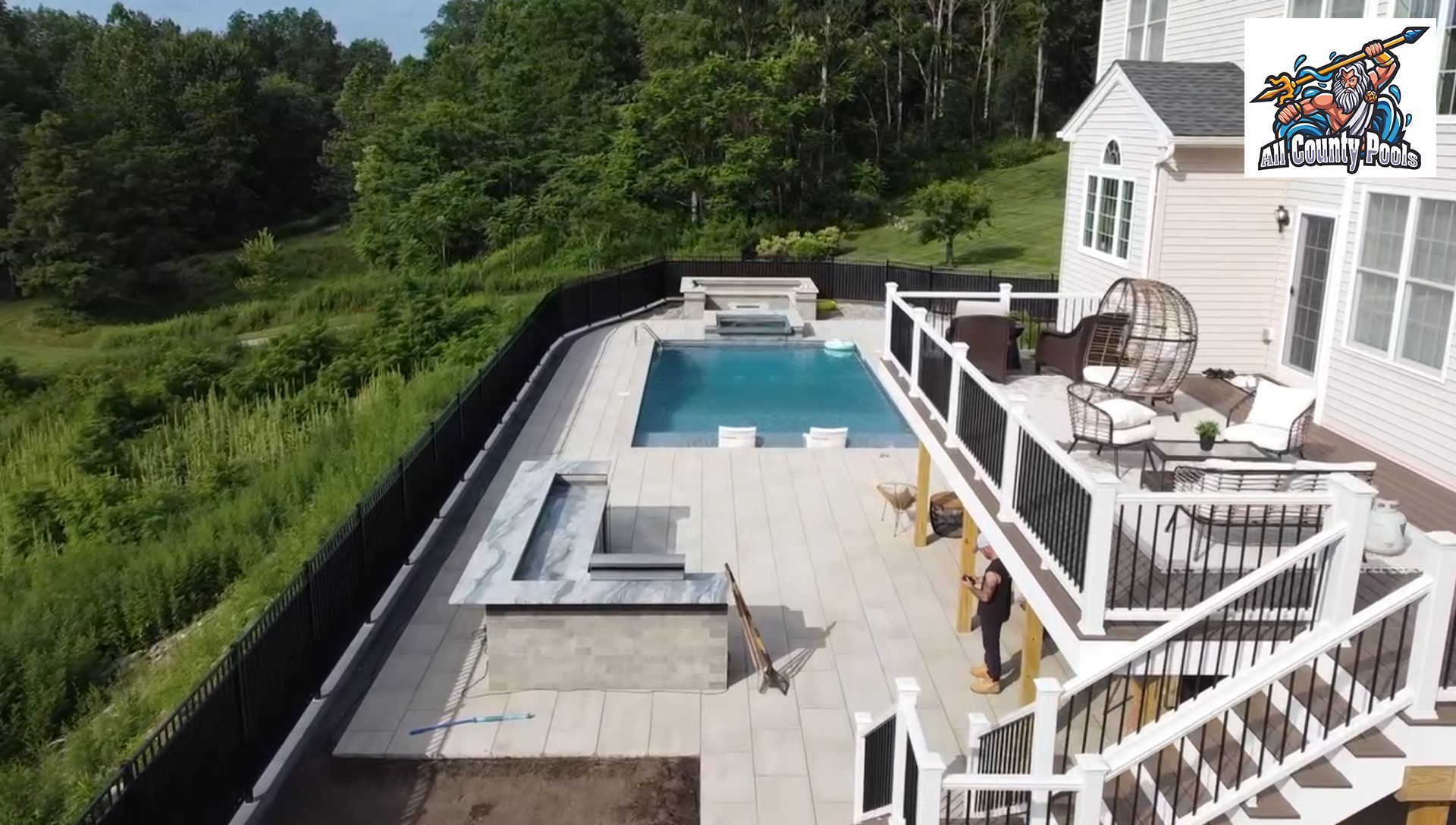An aerial view of a house with a swimming pool and a deck.