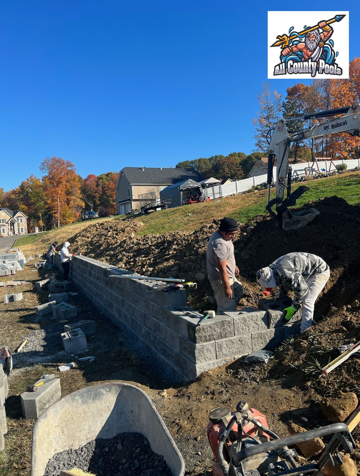 A couple of men are working on a brick wall.