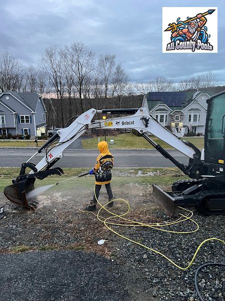 A little boy is standing next to a bulldozer on the side of the road.