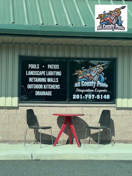 A red table and chairs are outside of a building.