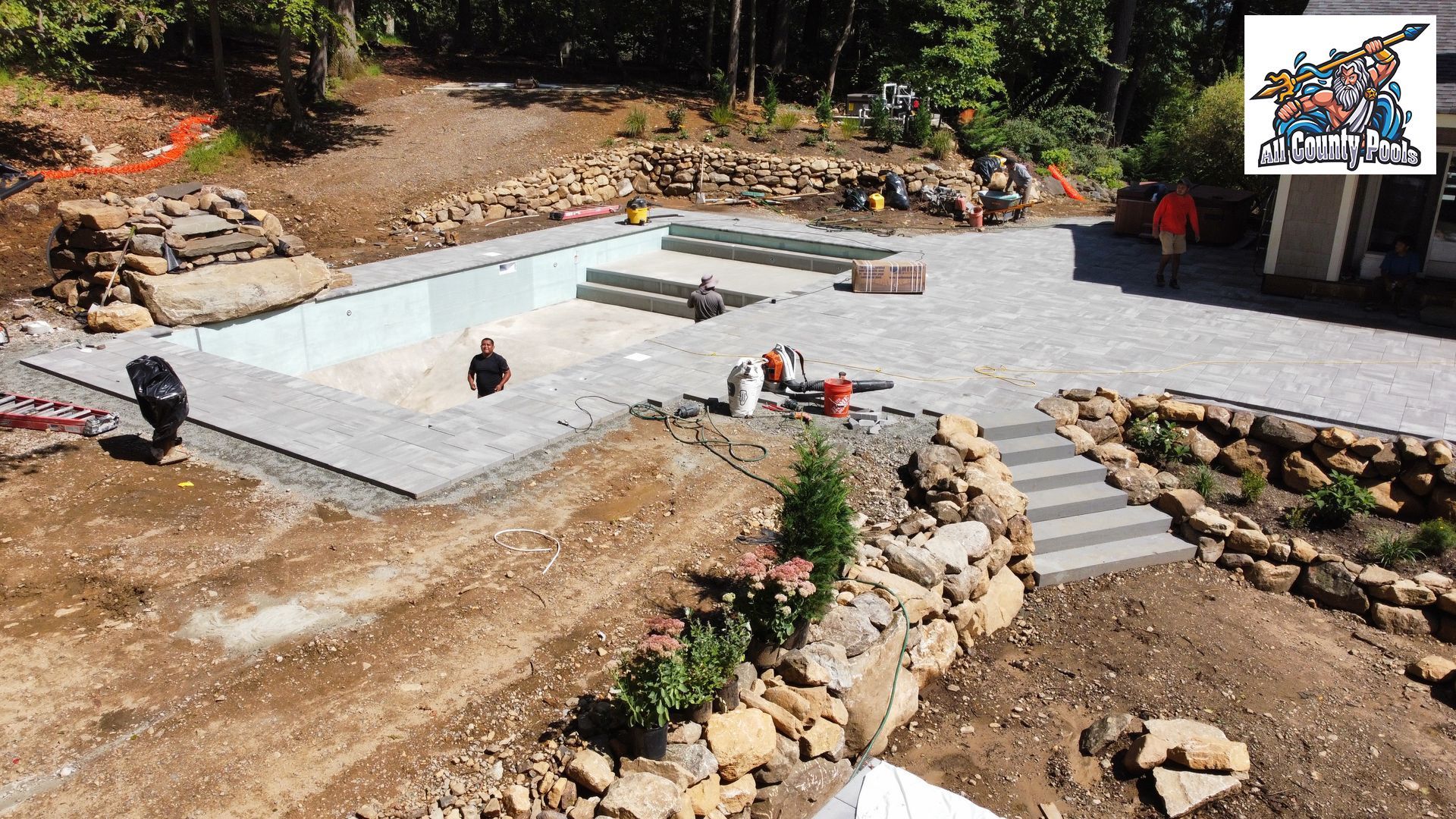 An aerial view of a swimming pool being built in a backyard.