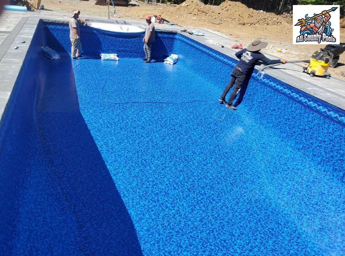 A man is standing on the edge of a blue swimming pool