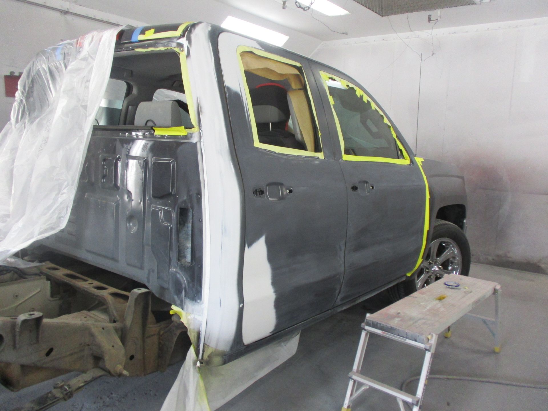 A car is being painted in a paint booth.