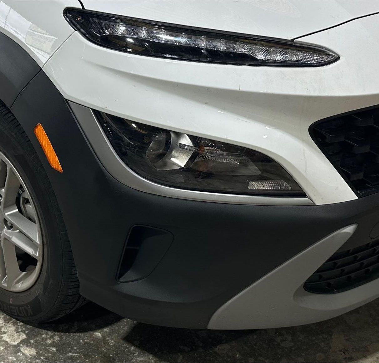 A close up of a white car with a black bumper