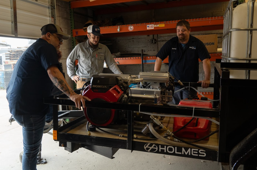 Three men are standing around a trailer