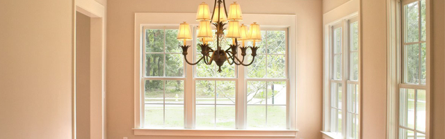 windows on beige walls and a chandelier
