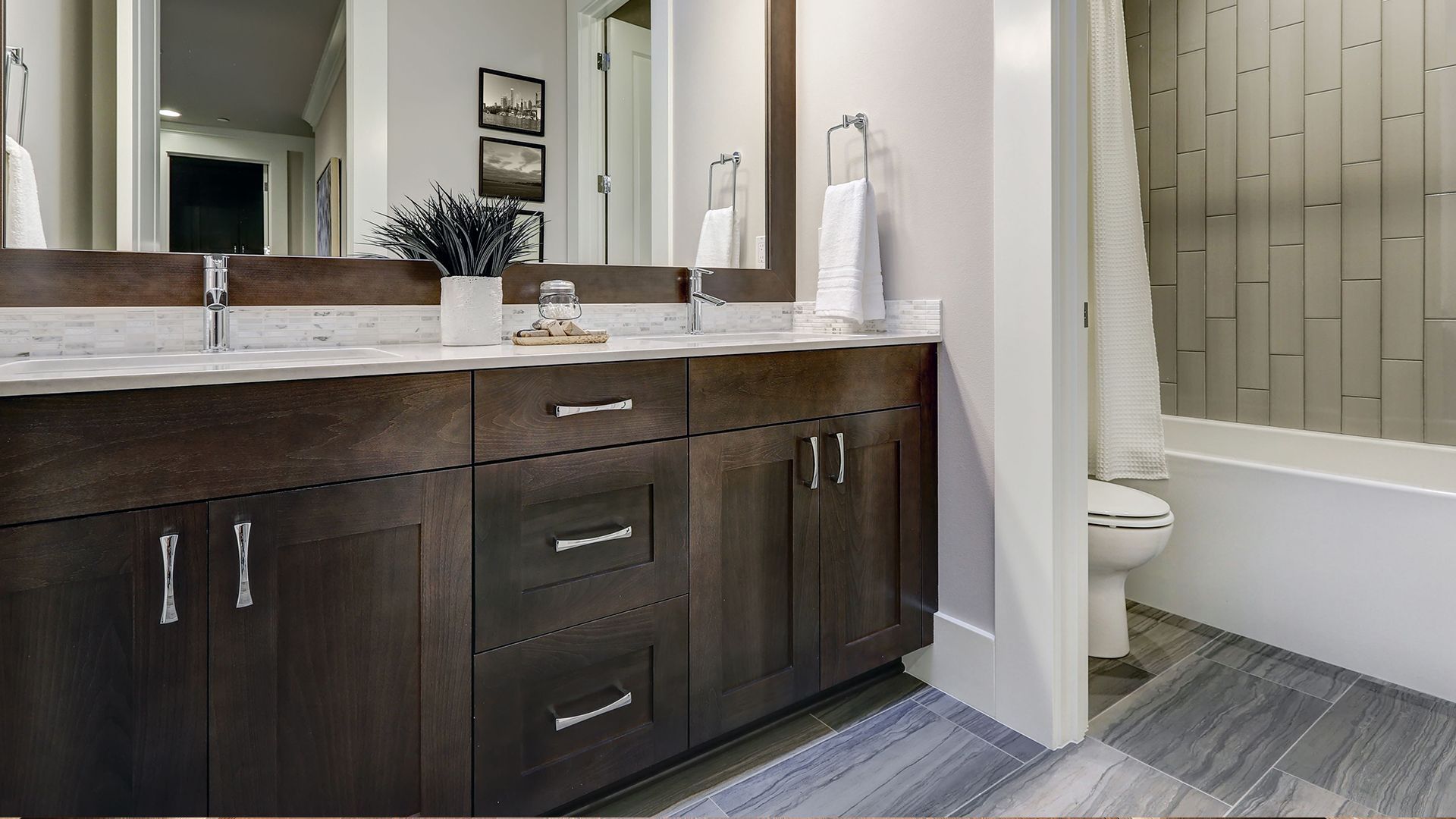 A bathroom with two sinks , a toilet , and a bathtub.
