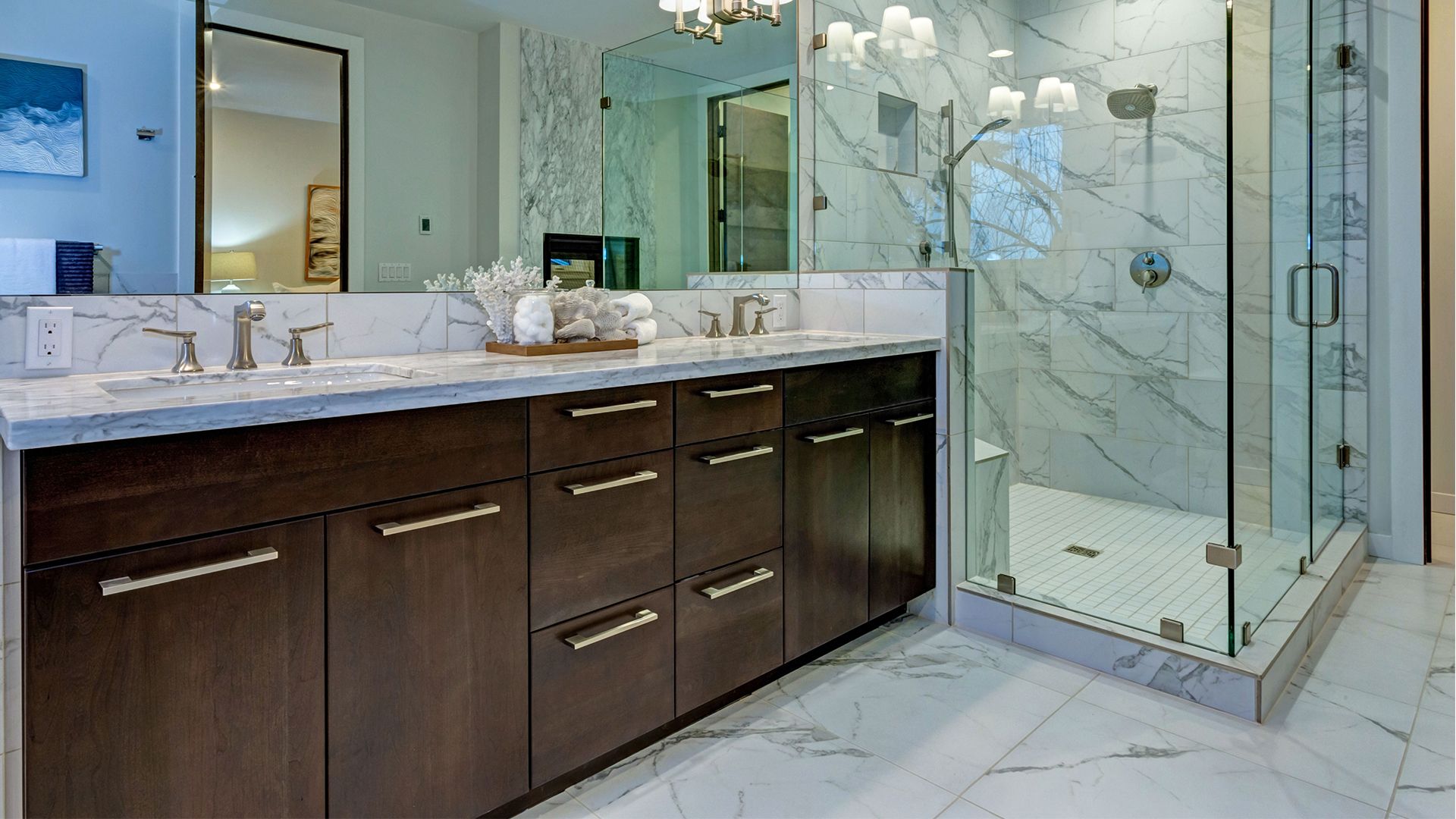 A bathroom with two sinks and a walk in shower.